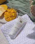 Mango Exfoliating Enzyme Masque on towel with mango