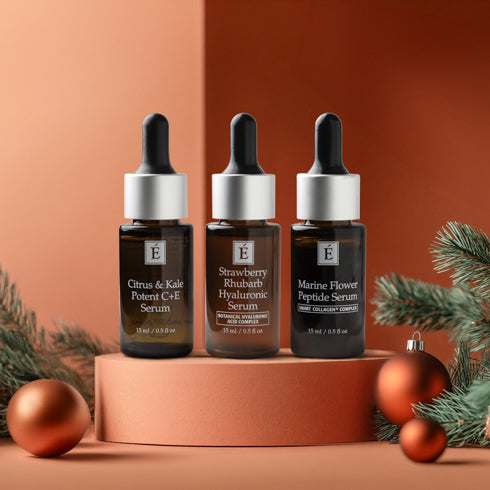 Three Eminence serums on display with holiday ornaments